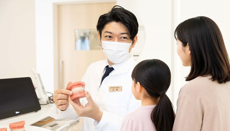 院長が親子に矯正治療について説明している様子